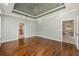 View of the spacious main bedroom showing hardwood flooring, tray ceiling, and access to the walk-in closet and ensuite bathroom at 8632 Sw 86Th Cir, Ocala, FL 34481