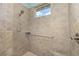 Close up of the tiled shower featuring a shower head, grab bar, and window at 8632 Sw 86Th Cir, Ocala, FL 34481