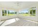 Bright sunroom with wood look flooring and many windows overlooking the yard at 8632 Sw 86Th Cir, Ocala, FL 34481