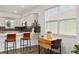 Bright kitchen featuring quartz countertops, stainless appliances, barstool seating, and an adjacent dining table at 8798 Sw 79Th Pl, Ocala, FL 34481