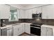 Beautiful kitchen features white cabinets, stainless steel appliances, and stylish tile backsplash at 8798 Sw 79Th Pl, Ocala, FL 34481