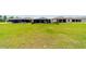 Expansive green backyard featuring a screened pool and covered patio, secured by a sleek black fence at 8875 Sw 58Th Street Rd, Ocala, FL 34481