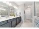 Bathroom with dual sink vanity with gray cabinets and a beautifully tiled glass-enclosed shower at 8875 Sw 58Th Street Rd, Ocala, FL 34481