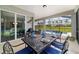 The covered patio offers an elegant dining set and seating area with views of the sparkling backyard pool at 8875 Sw 58Th Street Rd, Ocala, FL 34481