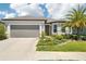 Inviting single-story home with a grey two-car garage, lovely landscaping and a stone facade at 8875 Sw 58Th Street Rd, Ocala, FL 34481