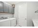 Bright laundry room features gray cabinets, a white washer and dryer, and neutral paint at 8875 Sw 58Th Street Rd, Ocala, FL 34481