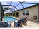 The screened-in pool area features stylish lounge chairs for relaxing on the pool deck at 8875 Sw 58Th Street Rd, Ocala, FL 34481