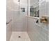Glass-enclosed shower featuring neutral tiles, a rainfall shower head, and built-in shelving at 8875 Sw 58Th Street Rd, Ocala, FL 34481