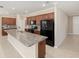 Large island in open kitchen with granite countertops, stainless appliances, and dark cabinets at 8952 Sw 79Th Ln, Ocala, FL 34481