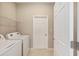 Bright laundry room with washer, dryer, wire shelving and a neutral color scheme at 8952 Sw 79Th Ln, Ocala, FL 34481