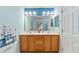 Bathroom featuring dual sinks, wood cabinets and a large framed mirror at 9175 Se 118Th Loop, Summerfield, FL 34491