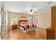 Bright bedroom features wood floors, ceiling fan, and a large window for natural light at 9175 Se 118Th Loop, Summerfield, FL 34491