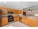 Open concept kitchen with wooden cabinetry and stainless steel appliances at 9175 Se 118Th Loop, Summerfield, FL 34491