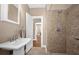 Bathroom featuring a pedestal sink, tiled shower, and access to a connecting room at 942 Ne 5Th St, Ocala, FL 34470
