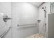 Bright shower with white tiled walls, river rock floor, and safety bars, designed for accessibility at 942 Ne 5Th St, Ocala, FL 34470