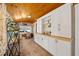 Sunny sunroom featuring a wood ceiling, built-in storage, and access to a desk area at 942 Ne 5Th St, Ocala, FL 34470