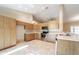 A bright kitchen with stainless steel appliances, light wood cabinets, and a tile floor at 9525 Sw 53Rd Cir, Ocala, FL 34476