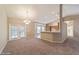 Open-concept living area featuring plush carpeting and a view of the kitchen and dining areas at 9525 Sw 53Rd Cir, Ocala, FL 34476
