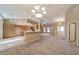 Open-concept living space with carpet, chandelier, ceiling fan, and view to the kitchen at 9525 Sw 53Rd Cir, Ocala, FL 34476