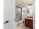 Well-lit bathroom featuring a vanity with granite countertop and a shower with glass doors at 9532 Sw 70Th Loop, Ocala, FL 34481