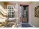 Close-up of front entrance with decorative door, welcome mat, bench, and manicured landscaping at 9532 Sw 70Th Loop, Ocala, FL 34481