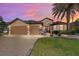 Charming home featuring a three-car garage, stone accents, well-manicured lawn, and beautiful landscaping at 9532 Sw 70Th Loop, Ocala, FL 34481
