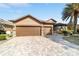 Lovely home showcasing a three-car garage, a brick-paved driveway and meticulous landscaping at 9532 Sw 70Th Loop, Ocala, FL 34481
