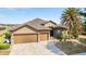 Charming home with a three-car garage, paver driveway, and mature landscaping around the entrance at 9532 Sw 70Th Loop, Ocala, FL 34481