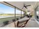 Covered screened patio offers a scenic view of the pond with fountains, seating area, and comfortable lounge chair at 9532 Sw 70Th Loop, Ocala, FL 34481