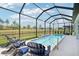 Relax by the screened pool with comfortable Adirondack chairs, creating a perfect outdoor retreat at 8875 Sw 58Th Street Rd, Ocala, FL 34481