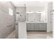 Bright bath with double sinks, gray cabinets, and a large glass enclosed shower with bench seating at 10589 Sw 98Th Ln, Ocala, FL 34481