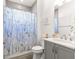 Bright bathroom features a gray vanity with a white countertop and a shower with a fun, daisy-patterned curtain at 10589 Sw 98Th Ln, Ocala, FL 34481