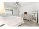 Bright bedroom features a ceiling fan, wood floors, and a matching wood dresser with mirror at 10589 Sw 98Th Ln, Ocala, FL 34481
