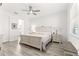 Bright bedroom features a ceiling fan, wood floors, and decoratively carved wood-frame bed and side tables at 10589 Sw 98Th Ln, Ocala, FL 34481