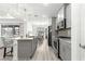 Well-lit kitchen features gray cabinets, granite countertops, stainless appliances, and an island with seating at 10589 Sw 98Th Ln, Ocala, FL 34481