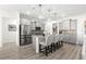 Well-lit kitchen features gray cabinets, granite countertops, stainless appliances, and an island with seating at 10589 Sw 98Th Ln, Ocala, FL 34481