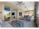 Comfortable screened lanai with ceiling fans, lounge seating, and a colorful flamingo-themed rug at 10589 Sw 98Th Ln, Ocala, FL 34481