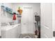 Well-organized laundry room with washer, dryer, shelving, and cleaning supplies at 10589 Sw 98Th Ln, Ocala, FL 34481