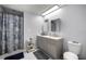 Bathroom with gray vanity, dual sinks, tub with shower, and decorative mirror at 1081 Se 170Th Ave, Silver Springs, FL 34488