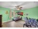 Bright bedroom featuring wood-look floors, light green walls, and a ceiling fan at 1081 Se 170Th Ave, Silver Springs, FL 34488