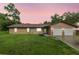 Dusk view of a ranch-style house with a well-kept lawn and two-car garage at 1081 Se 170Th Ave, Silver Springs, FL 34488