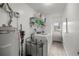 Clean laundry room featuring washer and dryer set, utility sink and open shelving at 1081 Se 170Th Ave, Silver Springs, FL 34488