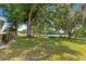 Expansive backyard featuring a lush green lawn and mature trees, creating a serene outdoor space at 10833 Sw 86Th Ter, Ocala, FL 34481