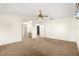 A neutral carpeted bedroom features an en suite bathroom, walk-in closet, and ceiling fan at 10833 Sw 86Th Ter, Ocala, FL 34481