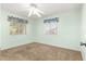 Carpeted bedroom with a ceiling fan and two windows offering natural light at 10833 Sw 86Th Ter, Ocala, FL 34481