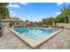 Triangular-shaped community pool with inviting clear blue water, surrounded by pavers, lounge chairs, lush greenery, and a clubhouse at 10833 Sw 86Th Ter, Ocala, FL 34481