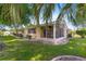 Exterior view of the back of the home showcasing a screened-in porch and backyard at 10833 Sw 86Th Ter, Ocala, FL 34481