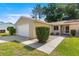 Front exterior view of a single-story home with a two-car garage and meticulous landscaping at 10833 Sw 86Th Ter, Ocala, FL 34481