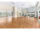 Large gym with wood floors, mirrors, exercise equipment, and ample space for fitness activities at 10833 Sw 86Th Ter, Ocala, FL 34481