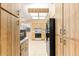 Galley kitchen with white tile floors, wood cabinets, and black appliances at 10833 Sw 86Th Ter, Ocala, FL 34481